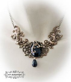 "♥♥Noir Romantique♥♥ Welcome to my store! \"Eternal beauty \"necklace A necklace comprised of 2 bronze rococo flourishes (42x22mm each) perfect detailed set on the left and right of bronze crown setting that is placed upon a central ornament in the middle and finally holds a get black gem 25x18mm. Flourish detail is attached to the gem. Black teardop bead is hanging. ------- If you need a specific lenght contact me :) ------------ ♥♥ The metal parts are of high quality brass ♥♥ Nickel and lead f Gothic Pendant Necklace With Antique Finish, Gothic Gold Pendant Necklace, Gothic Gold Necklace For Wedding, Gold Gothic Necklace For Wedding, Gothic Bronze Jewelry With Antique Finish, Gothic Metal Necklace With Antique Finish, Gothic Gold Filigree Jewelry, Gothic Metal Necklace With Intricate Design, Gothic Black Brass Necklace