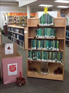 a book shelf filled with lots of books next to a red and white striped box