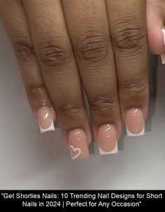 a woman's hand with french manies and hearts on it, while she has her nails painted white