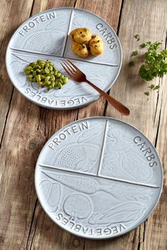 two plates with food on them sitting on a wooden table next to a knife and fork