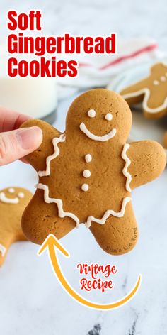 a hand holding a gingerbread cookie in front of other cookies on a table with the words soft gingerbread cookies above it