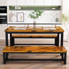 a kitchen table with two benches and a potted plant on the counter in front of it