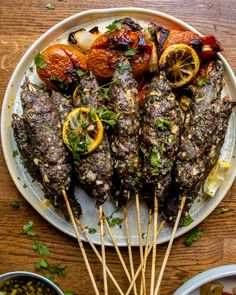 grilled meat and vegetables on a plate with skewers