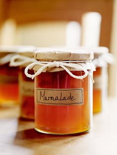 three jars filled with honey sitting on top of a table