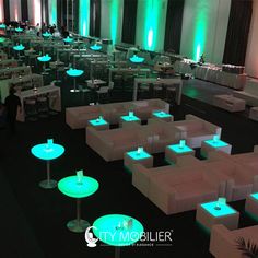 an empty banquet hall with tables and chairs lit up in green lights for the event