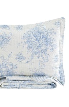 the blue and white floral print is on top of this quilted bedding set