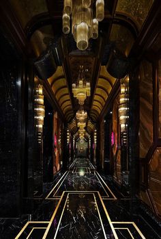 an elegant hallway with chandeliers and black marble flooring is seen in this image