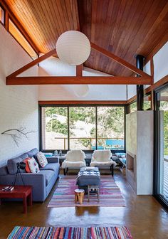 a living room with couches, rugs and large windows