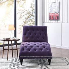 a purple chair sitting on top of a rug in a living room next to a window