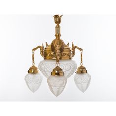 an ornate chandelier with four glass shades hanging from it's center point