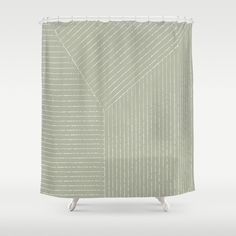 a green shower curtain with white lines on the bottom and sides, in front of a gray background