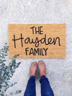 a person standing in front of a door mat that says the hagsden family