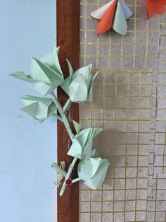 three paper flowers are on the wall next to each other