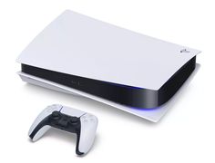 a white and black video game system with two controllers next to it on a white surface