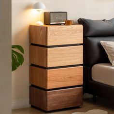 a wooden cabinet sitting next to a couch in a room with a lamp on top of it