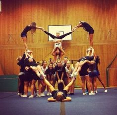 a group of cheerleaders are doing tricks on the court