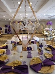 a table set up with purple and gold place settings