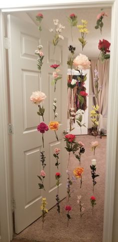 flowers are hanging from the ceiling in front of a door with an open doorway behind them