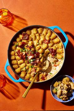 a pan filled with tater tots on top of a table next to drinks