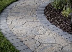 a stone path in the middle of some grass