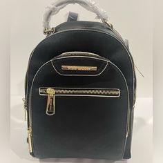 Steve Madden Black Backpack With Tan Trim And Gold Hardware. Brand Nwt And Plastic Still Attached. 3 Zippers, Large Opening, Small Opening And Front Pocket Zipper Pocket Inside With Two Pockets L 9’ X H 11.5’ X W 6’ X Handle 3’ Elegant Black Backpack With Gold-tone Hardware, Black Backpack With Gold-tone Hardware For On-the-go, Black Backpack With Gold-tone Hardware, Black Leather Backpack With Gold-tone Hardware For Travel, Black Backpack With Gold-tone Hardware For Travel, Black Standard Backpack With Gold-tone Hardware, Black Backpack With Gold-tone Hardware For Daily Use, Chic Black Backpack With Zipper Pocket, Elegant Crossbody Backpack With Zipper