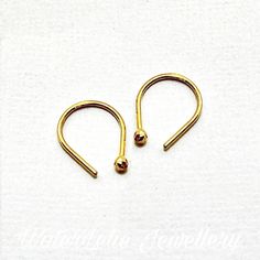 "Solid 24k gold earrings. Ball earrings. Minimalist earrings. 24k gold Huggies. Hand forged solid 24k gold. Hypo allergenic earrings. Read description These are solid 24k gold earrings. I hand forge them in my studio and they are shipped with rubber guards. Ball nugget is approx. 2 mm and length of earring 1/2\" (13 mm). Tiny earrings. As with any handmade or forged jewelry, the earrings will have a nugget ball end (not perfectly round or smooth) and the post is forged (not smooth). Also availab Small Hoop Gold Cartilage Earrings As Gift, Gold Recycled Gold Huggie Earrings Gift, Handmade 14k Yellow Gold Huggie Earrings, Minimalist Gold Huggie Earrings As Gift, Gold Recycled Gold Huggie Earrings, Gold Huggie Hoop Earrings In Recycled Gold, Yellow Gold Brass Huggie Earrings Gift, Adjustable Yellow Gold Cartilage Earrings With Ear Wire, Minimalist Handmade Gold Cartilage Earrings