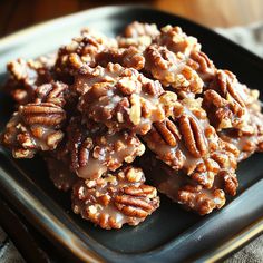 a plate full of pecans with chocolate drizzled on top and nuts in the middle