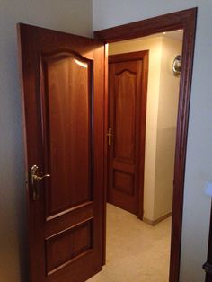 an open door in a hallway leading to another room with two doors on either side