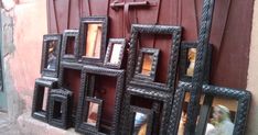 a group of frames sitting on the side of a building