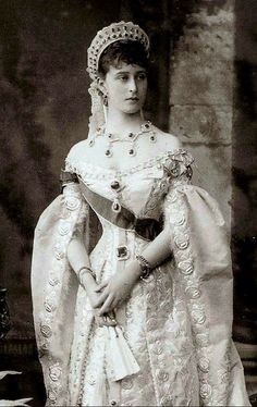 an old black and white photo of a woman in a dress with a tiara