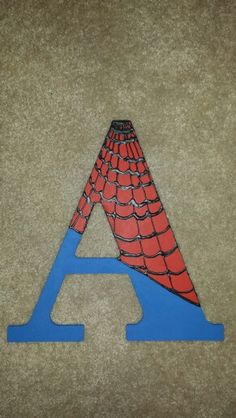 a blue and red letter with a spiderman on it's face, sitting on the floor