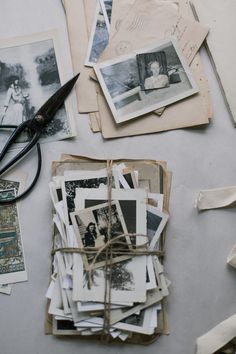 an assortment of old photos and scissors on a table