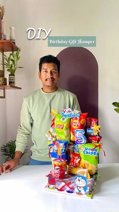 a man standing in front of a pile of snacks on top of a white table