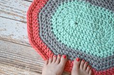 a woman's feet are on top of a crocheted rug that looks like a circle