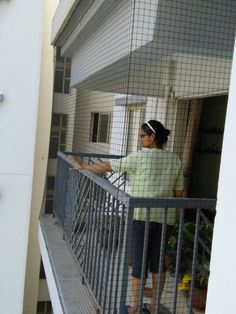 a woman is standing on the balcony railing