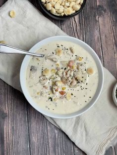 a white bowl filled with soup next to two bowls of food