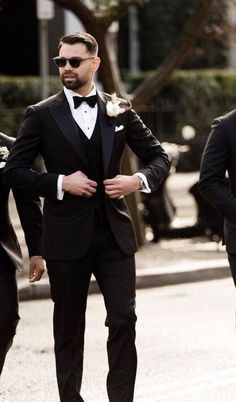 a man in a tuxedo is walking down the street