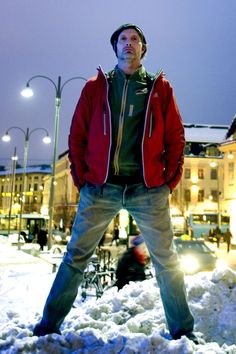 a man standing in the snow with his hands on his hips