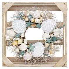 a wreath with seashells and sea urns on it in a wooden frame