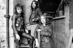 an old black and white photo of three men in leather outfits posing for the camera