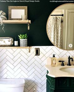 a bathroom with green walls and white tile on the wall, along with a mirror