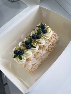 a piece of cake in a box with blueberries on top