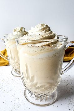 two glasses filled with whipped cream on top of a table