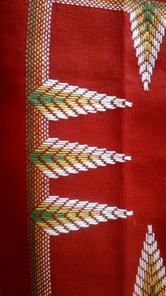 a red cloth with white and green designs on it's edges is seen in close up