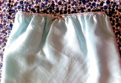 a white and blue skirt on top of a leopard print bed spread with polka dots