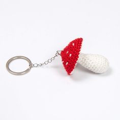 a crocheted keychain with a red and white object on it's side