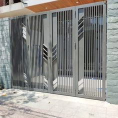 an iron gate is open on the side of a building