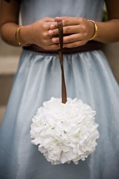 a woman in a blue dress holding a white bouquet