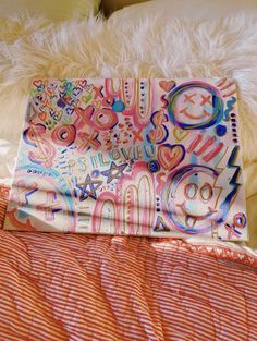 an orange and white bed spread with colorful designs on it