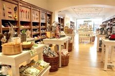 the inside of a shoe store with lots of shelves and baskets full of shoes on them